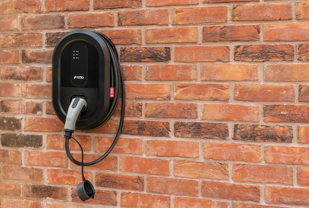 Electric vehicle charging station mounted on a red brick wall.